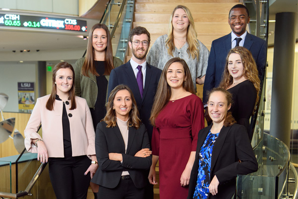 Group of students pose for photo on staircase. 