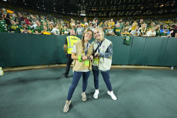 Julia Palin (left) with coworker at football game.