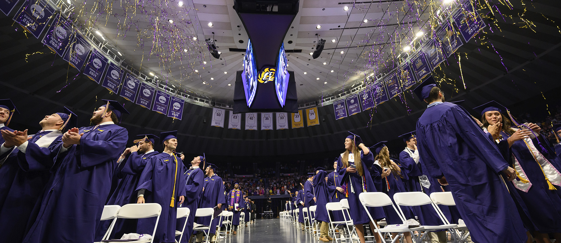 Students in PMAC standing under confetti at graduation