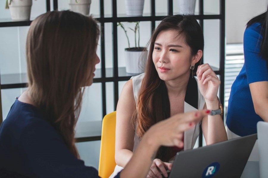 two people talk intently in front of a computer