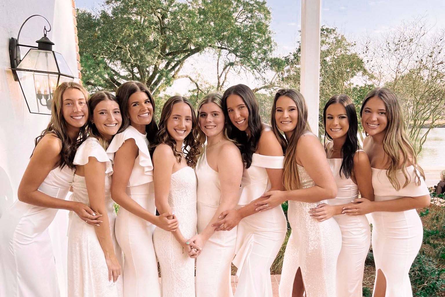 delta zeta members pose in white