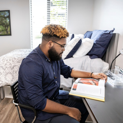 student reading in res hall room